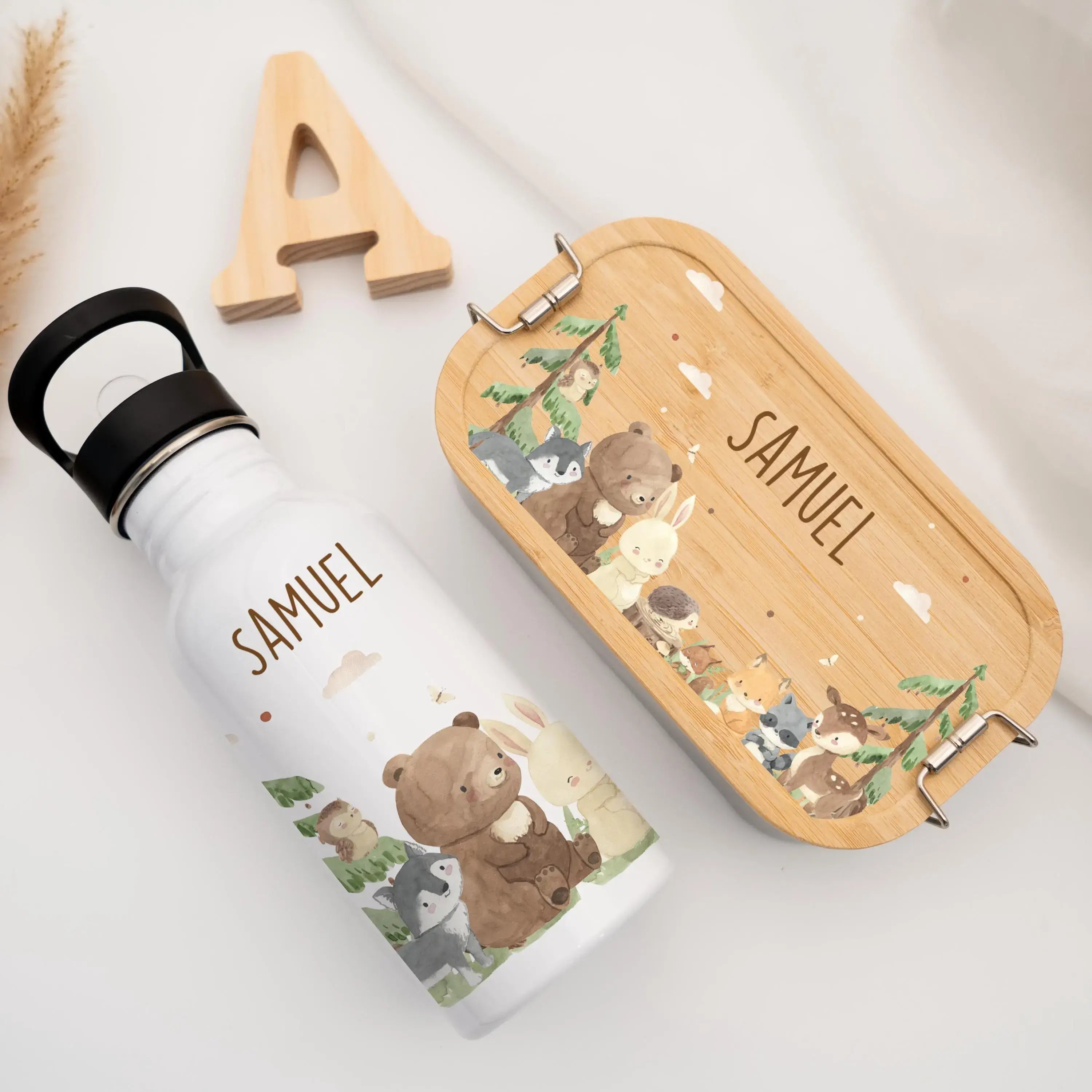 Personalisierte Trinkflasche und Brotdose auf Boden fotografiert von oben mit Waldtier Motiv