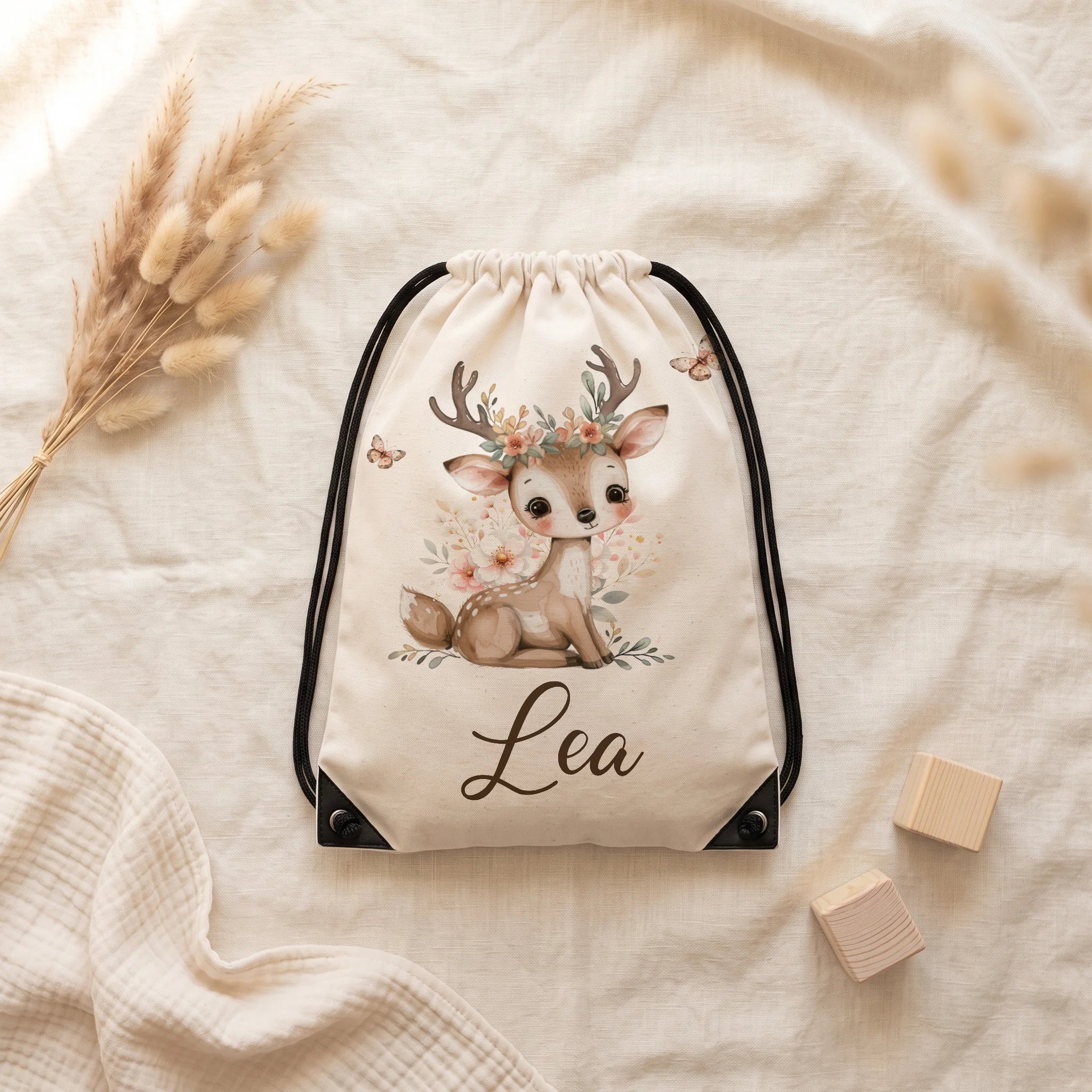 Sac de sport personnalisé posé à plat sur du lin, motif faon et papillons — Kidsmood