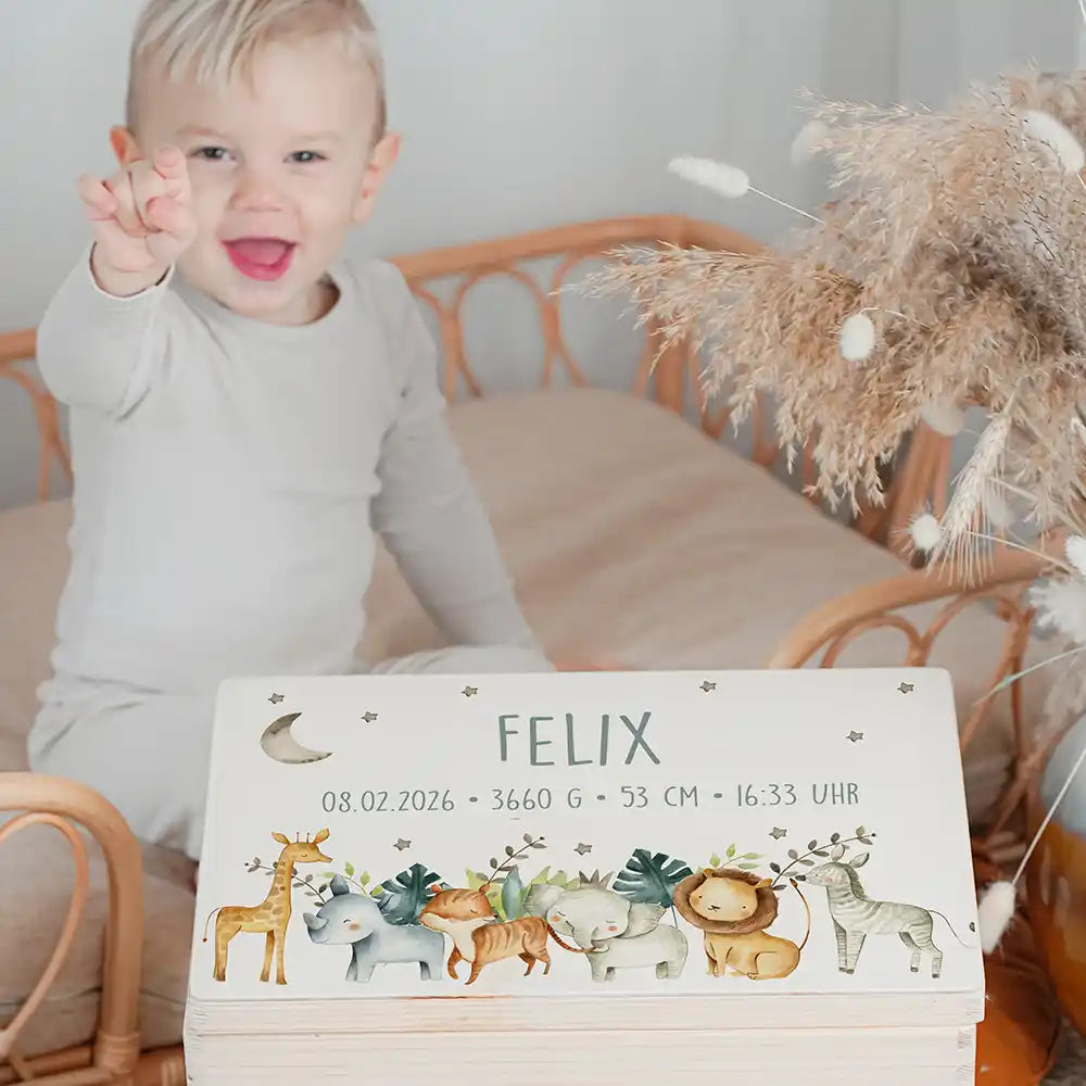 Boîte à souvenirs bébé personnalisée Animaux de la savane – enfant souriant à côté du coffret personnalisé