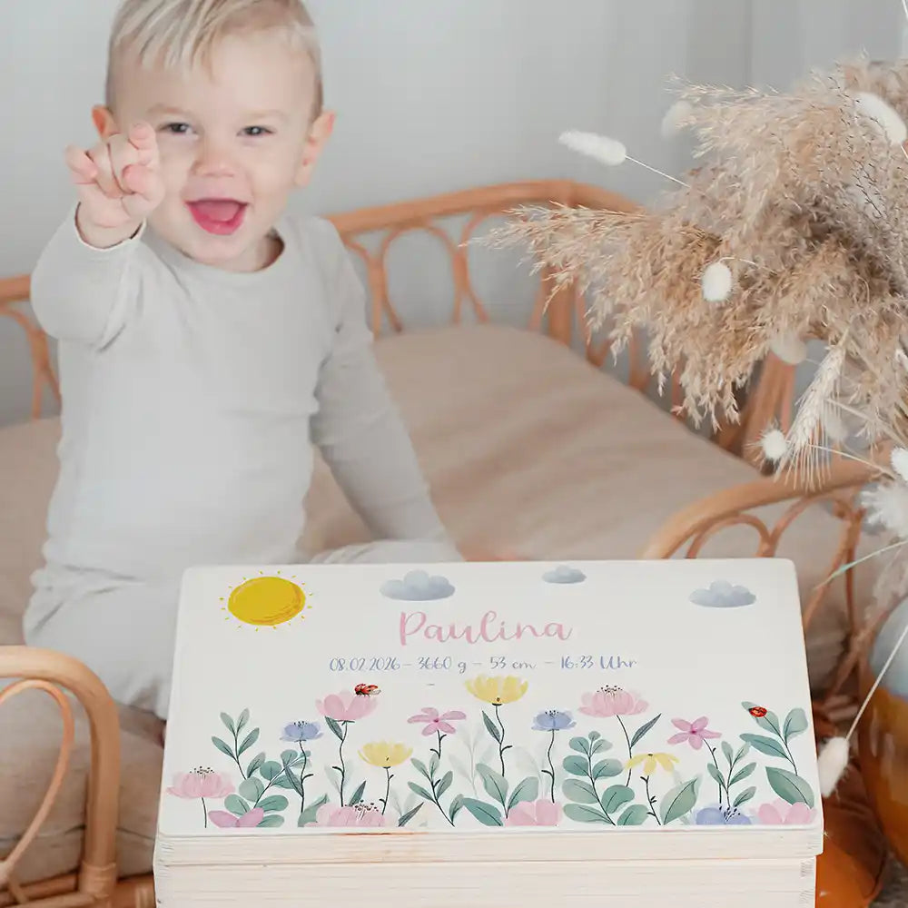 Boîte à souvenirs bébé personnalisée Fleurs sauvages – enfant souriant à côté du coffret personnalisé