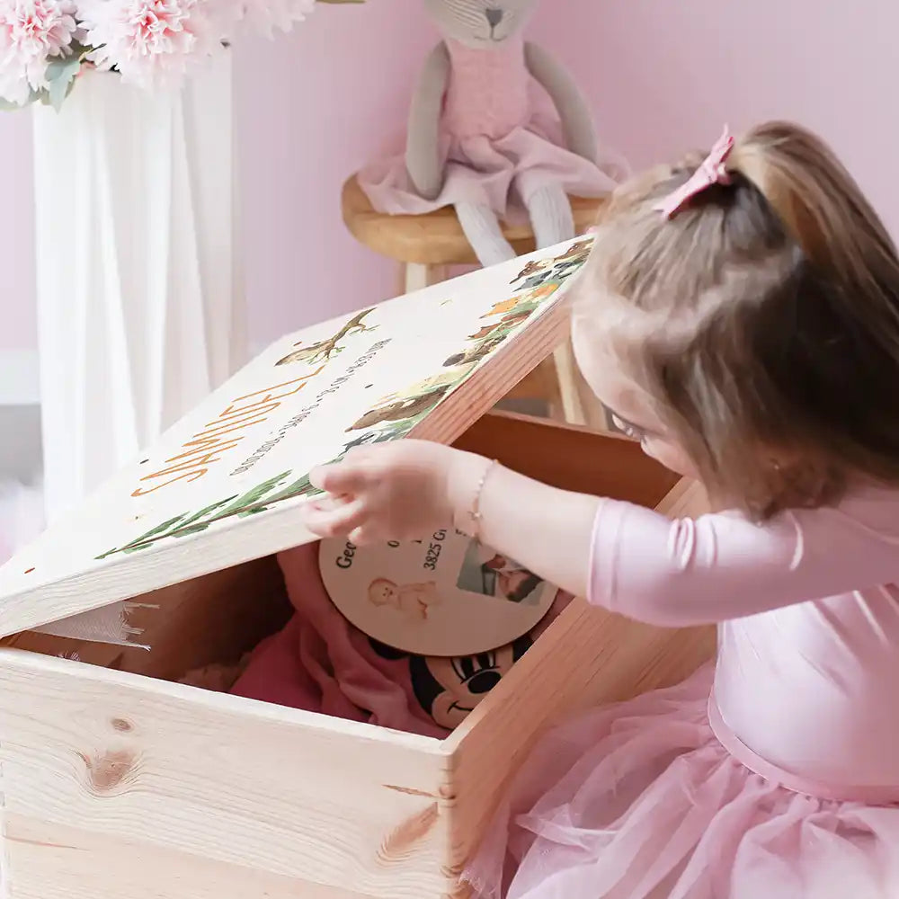 Boîte à souvenirs bébé personnalisée Animaux de la forêt – enfant ouvrant sa boîte remplie de souvenirs