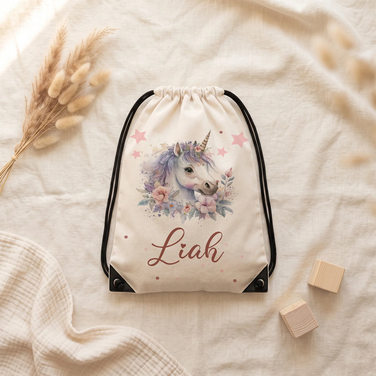 Sac de sport personnalisé posé à plat sur du lin, motif licorne fleurie — Kidsmood