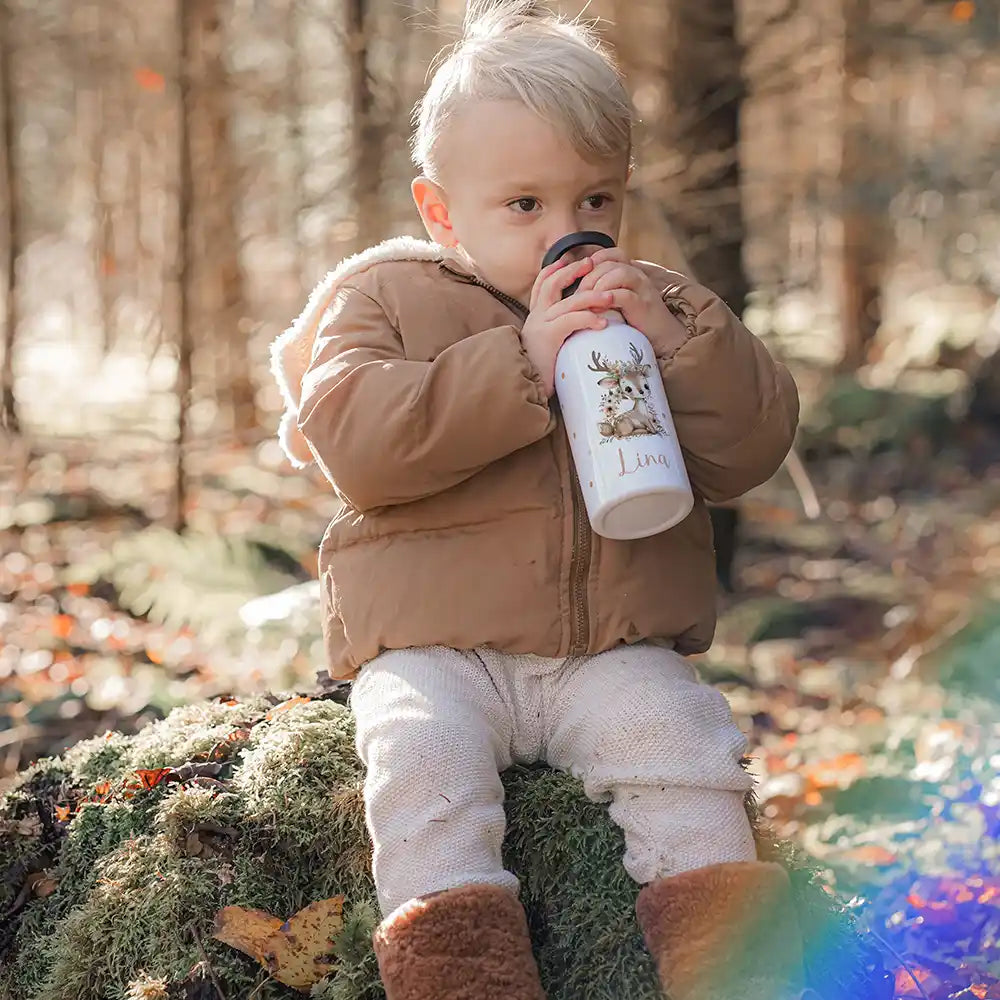 Enfant buvant à sa gourde personnalisée motif Faon fleuri en forêt — Kidsmood