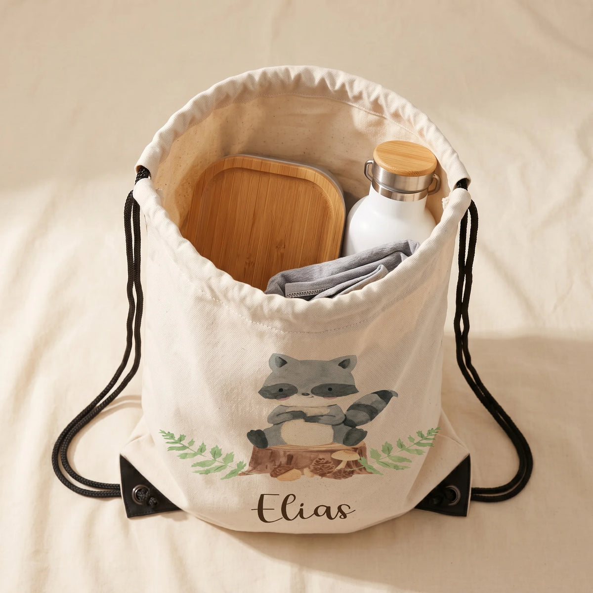 Sac de sport enfant ouvert avec affaires de sport et gourde, motif raton laveur — Kidsmood