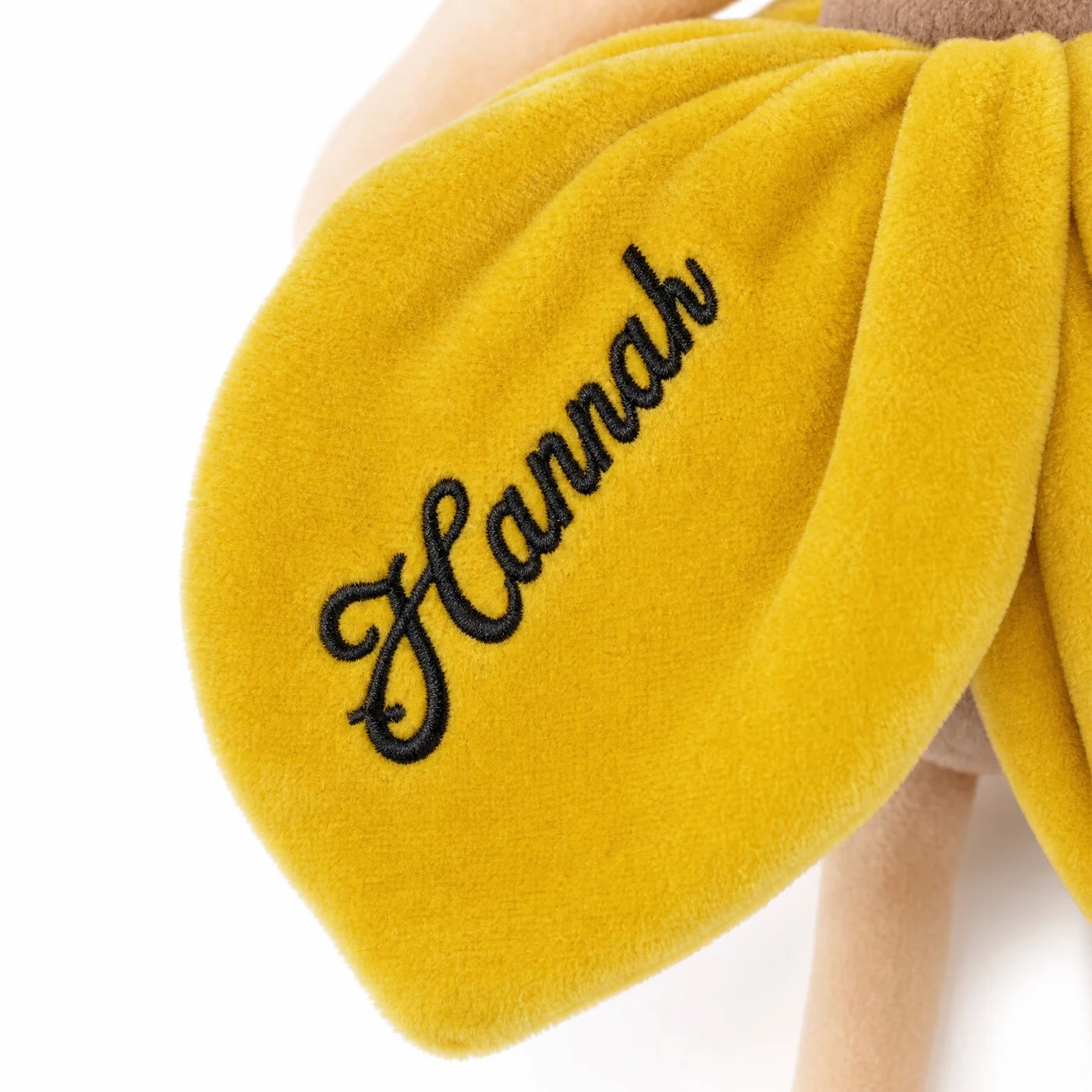 Gros plan sur le prénom brodé en fil noir sur la robe jaune miel — Kidsmood