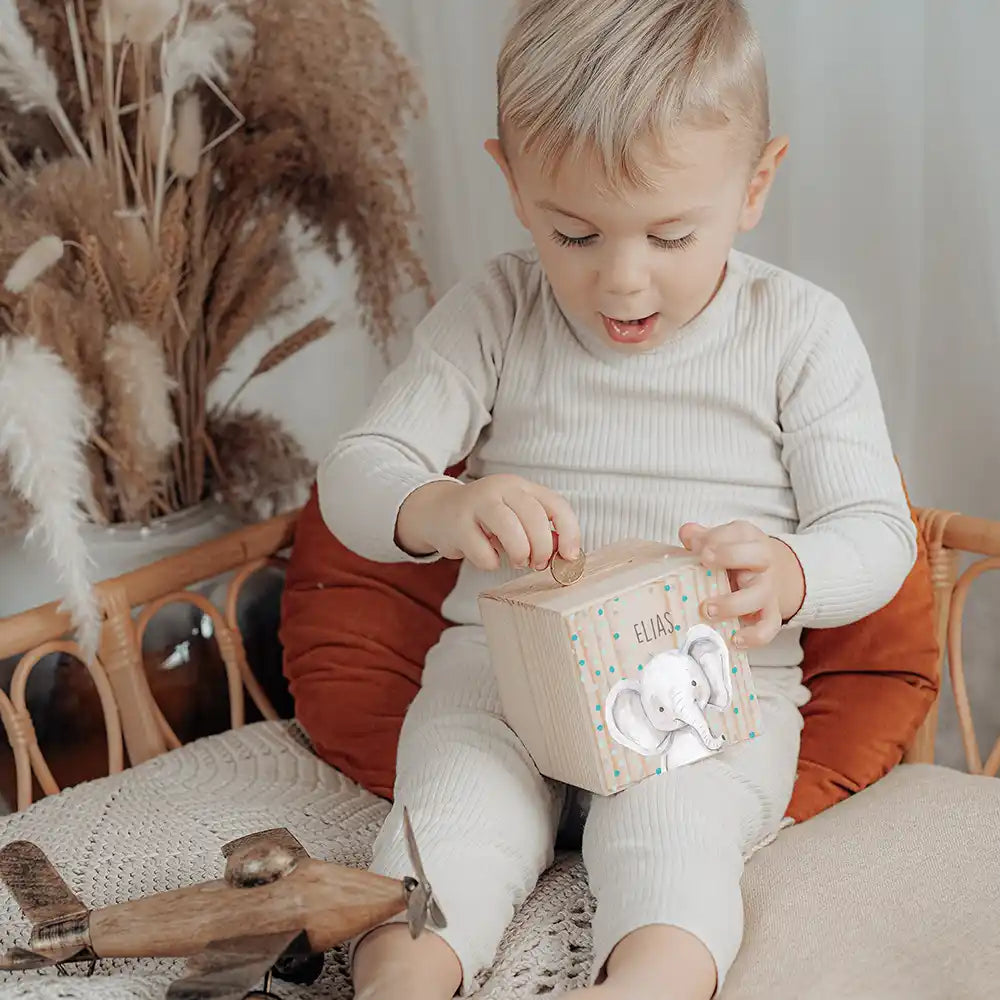 Enfant glissant une pièce dans sa tirelire personnalisée, motif éléphant confettis — Kidsmood