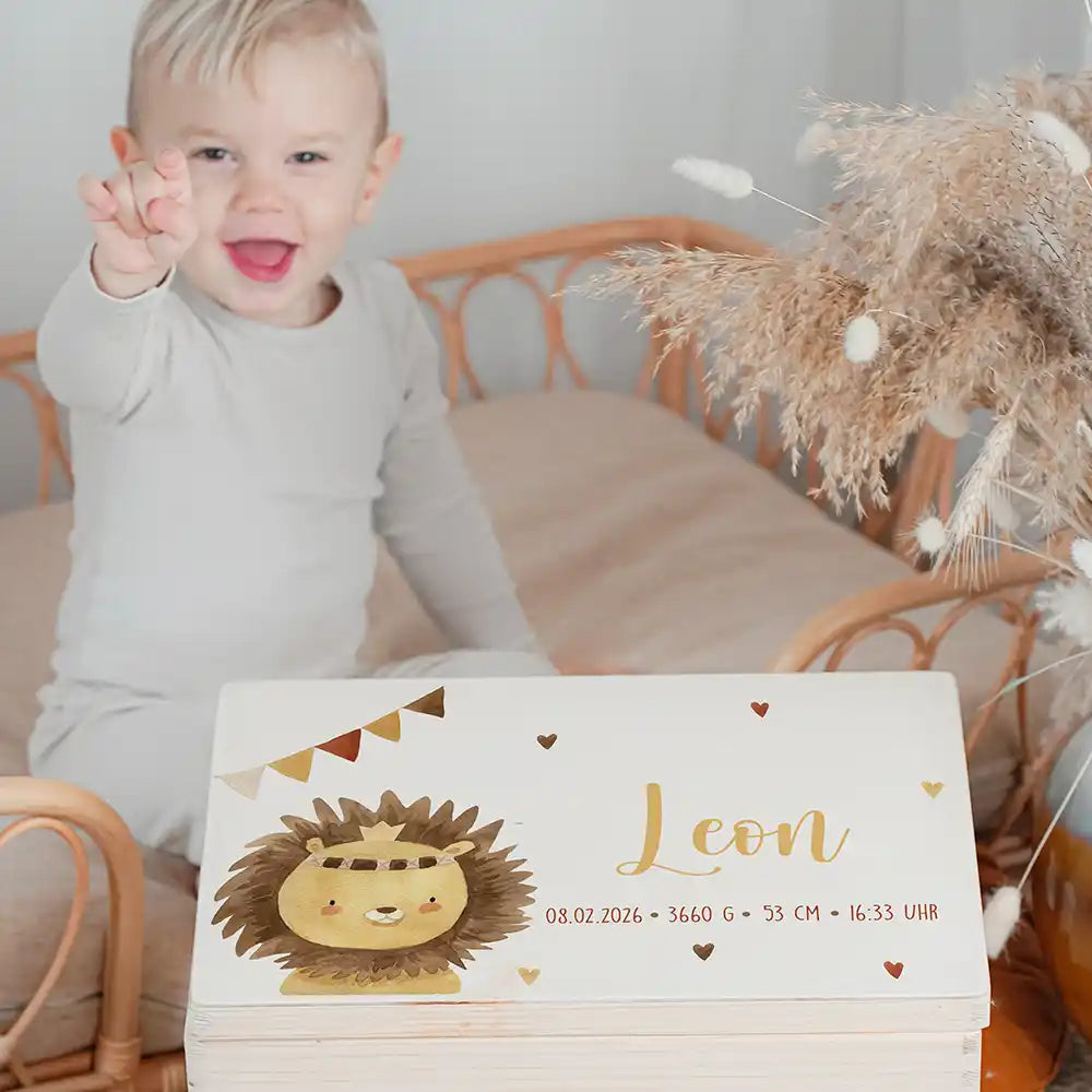 Boîte à souvenirs bébé personnalisée Petit lion – enfant souriant à côté du coffret personnalisé
