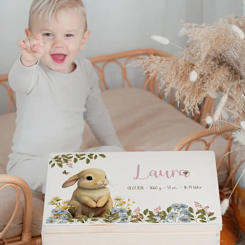 Boîte à souvenirs bébé personnalisée Petit lapin – enfant souriant à côté du coffret personnalisé