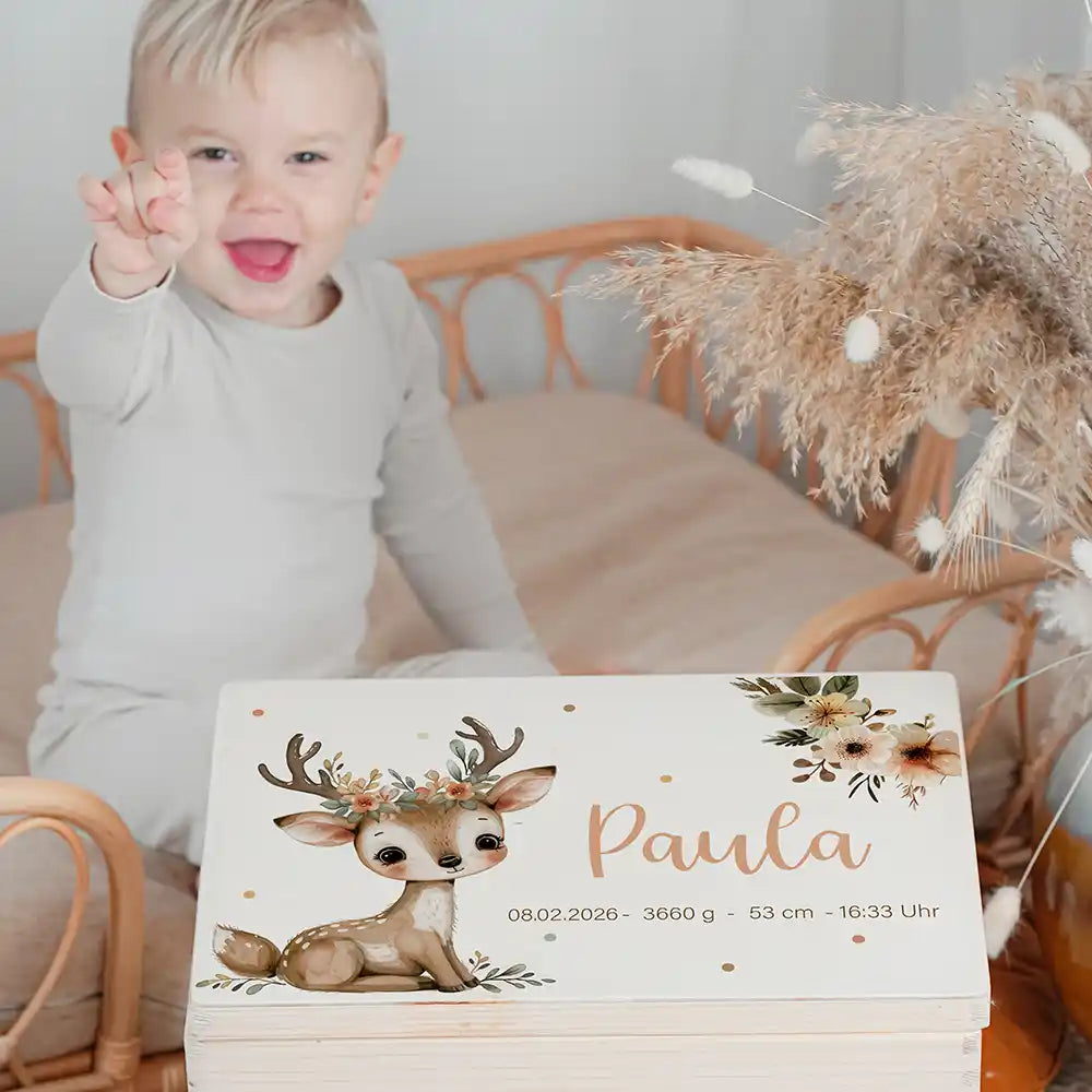 Boîte à souvenirs bébé personnalisée Faon couronne de fleurs – enfant souriant à côté du coffret personnalisé