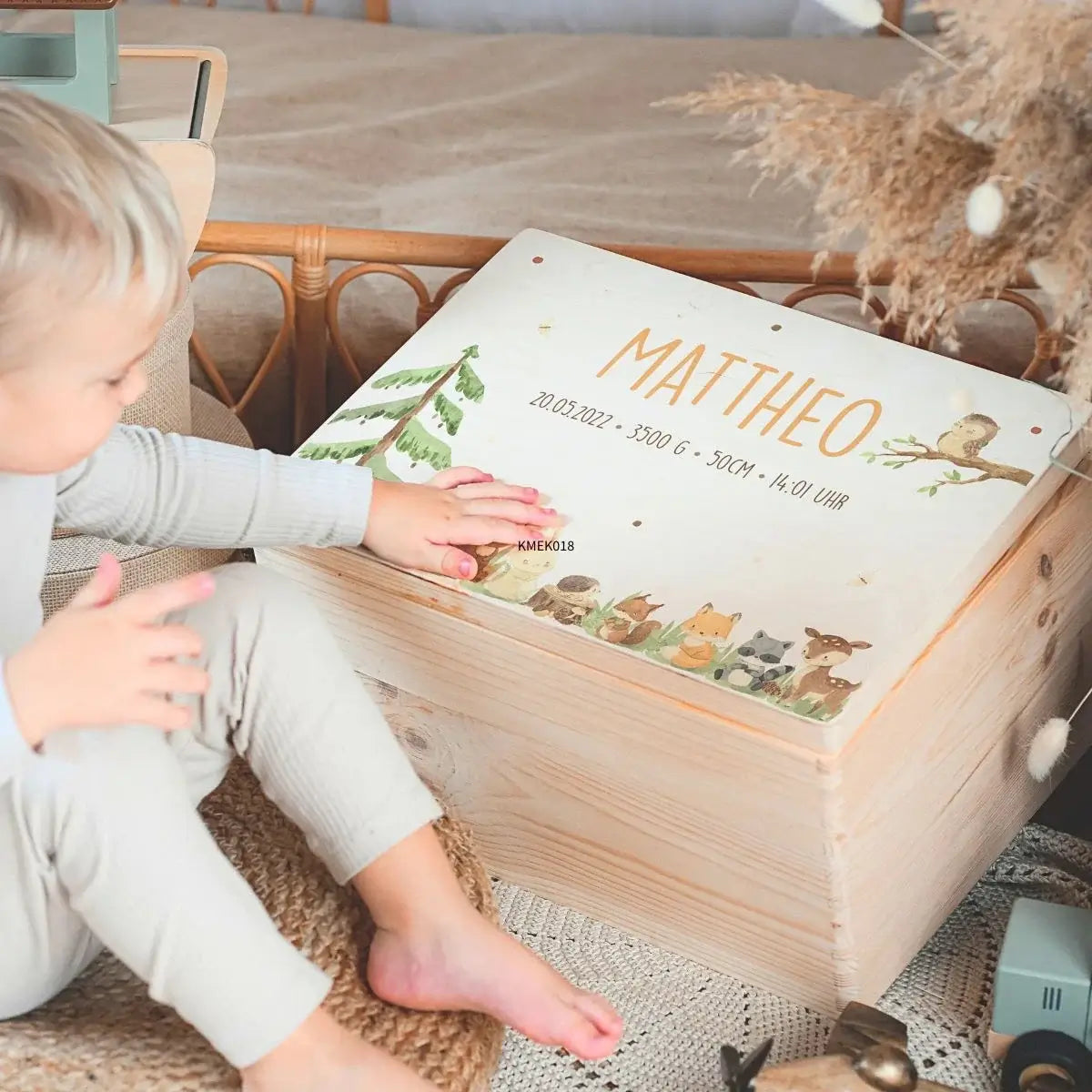Lächelndes Kind mit personalisierter Holzkiste "Mattheo" - Erinnerungsbox Geburt mit Waldtieren und Geburtsdaten graviert