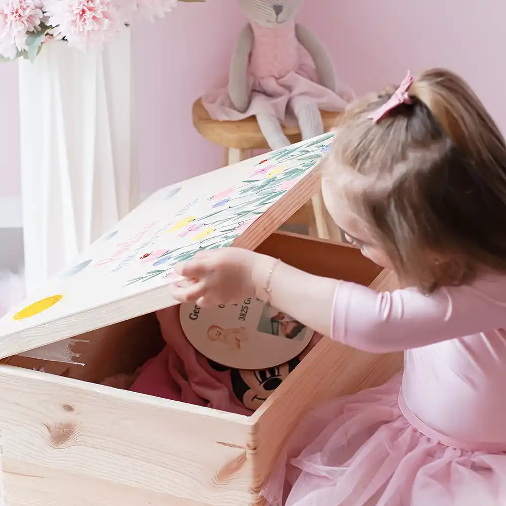 Boîte à souvenirs bébé personnalisée Fleurs sauvages – enfant ouvrant sa boîte remplie de souvenirs