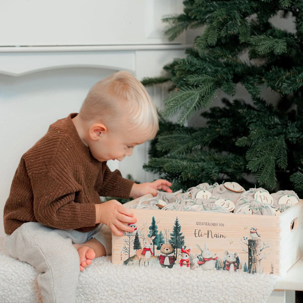 Kind im braunen Strickpullover öffnet personalisierten Adventskalender 